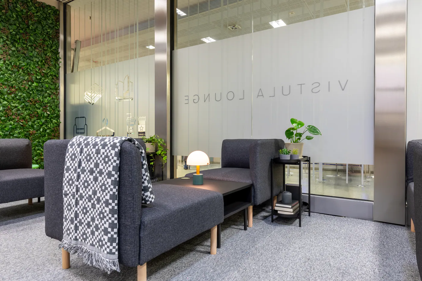 Comfortable grey lounge seating beside the station concourse